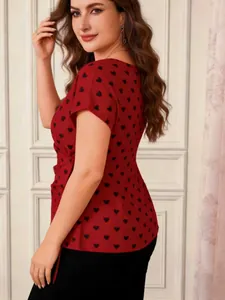 Side view of a red plus size blouse featuring black heart prints and a side waist tie.