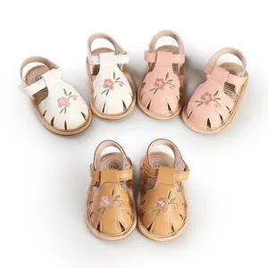 Detailed view of baby girl embroidered floral sandals in white, pink, and tan