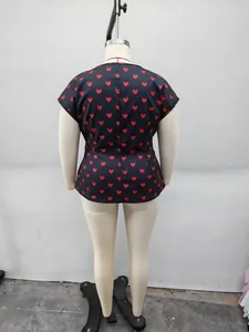 Back view of a plus size black short sleeve top with red heart print on a mannequin