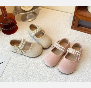 Close-up detail of girls' suede princess shoes with pearl straps and bows in macaron colors