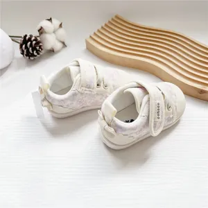 Top-down view of floral baby sneakers featuring brand logo on adjustable straps.