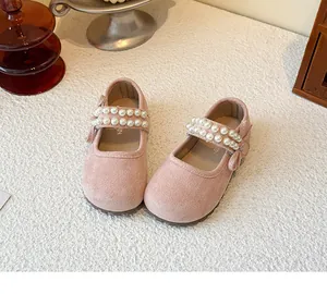 Detailed macro view of pink suede children's Mary Jane shoes with elegant pearl straps