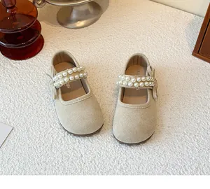 Detail shot of beige girls' Mary Jane shoes featuring elegant double pearl straps.