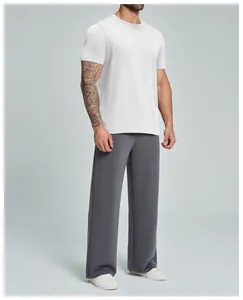 Vista de cuerpo completo de camiseta blanca de algodón orgánico y pantalón ancho gris para hombre.