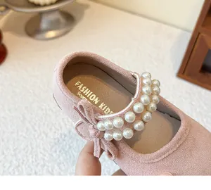 Detail view of pink girl's princess shoe with elegant double pearl straps and bow