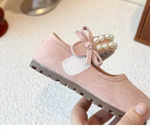 Detailed macro view of pink princess shoes for girls with pearl strap and bow decoration