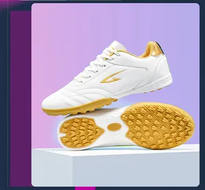 White TF turf soccer shoes with gold logo showing side profile and sole traction pattern
