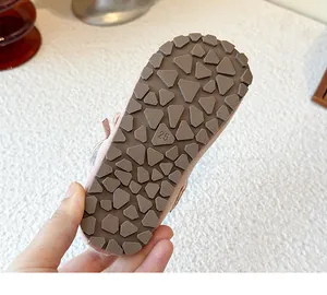 Detailed view of the anti-slip brown rubber sole of pink girls' princess shoes
