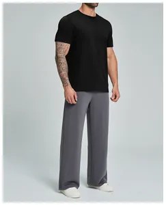 Vista completa de hombre con camiseta negra de algodón orgánico y pantalón gris