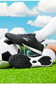 Detailed view of black TF soccer cleats showing stud pattern and side profile