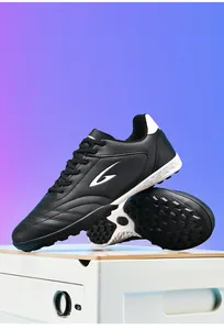 Black TF turf soccer shoes for youth and adults with breathable synthetic upper texture.