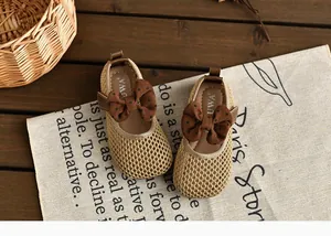 Détail de sandales en maille respirante pour filles avec un joli nœud marron à pois