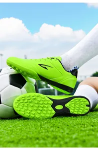 Close-up of lime green TF turf soccer shoes showing sole grip and side design