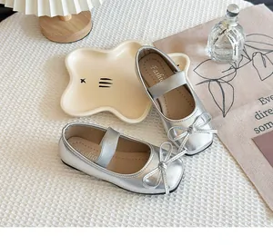 Detailansicht silberner Mary Jane Schuhe für Mädchen mit Schleife und Metallic-Finish.