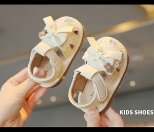 Nahaufnahme von atmungsaktiven Baby-Sandalen mit dekorativer Schleife und weicher Sohle