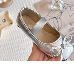Nahaufnahme von glänzenden silbernen Mädchen-Ballerinas mit dekorativer Schleife.
