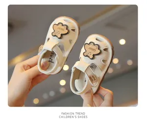 Detailed view of beige baby toddler sandals featuring soft soles and cute bear charms