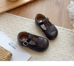 Detailed view of children's vintage brown leather T-strap shoes with brogue details