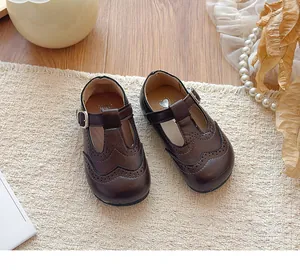 Vintage dark brown children's T-strap leather shoes with classic British brogue detailing