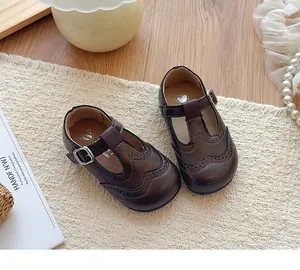 Vintage brown T-strap leather shoes for girls featuring elegant brogue wingtip detailing.