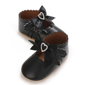 Detailansicht der schwarzen Baby-Prinzessin-Schuhe mit schöner Satinschleife und Herz.