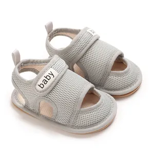Nahaufnahme graue atmungsaktive Baby-Sandalen mit weicher Sohle und Klettverschluss-Label