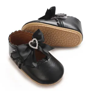Detailansicht der weichen Sohle und Herz-Strass-Schleife an schwarzen Baby-Prinzessin-Schuhen.