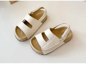 Dettaglio di sandali beige per bambini con suola antiscivolo e cinturino regolabile