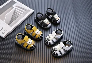 Detailed view of baby boy's closed-toe sandals with cartoon bear in three colors