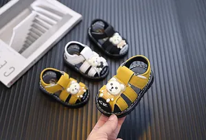 Detailed view of yellow cartoon bear toddler sandals with soft anti-slip soles