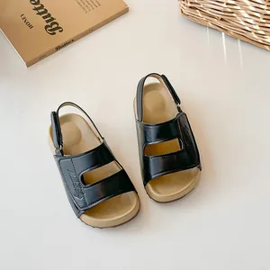 Sandali neri minimalisti per bambini con suole antiscivolo e cinturini regolabili.
