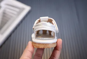 Vista detallada de sandalias blancas para bebés niñas con suela de goma suave flexible
