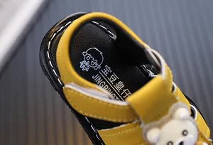 Detailed macro view of a yellow baby sandal showing the soft inner sole and stitching.