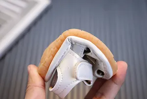Detalle de cerca de la suela suave y flexible de las sandalias blancas para bebés primeros pasos
