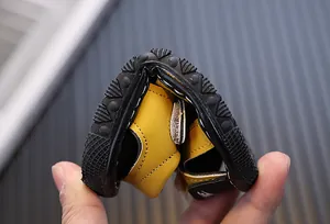 Flexible soft sole demonstration of yellow toddler boy closed-toe squeaky sandals
