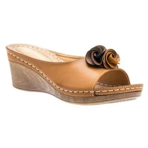 Detalle de sandalias de cuña marrón con flores decorativas y suela de plataforma de madera