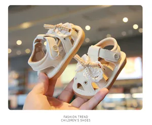 Close-up of beige baby hollow-out sandals with lace bow and breathable soft sole