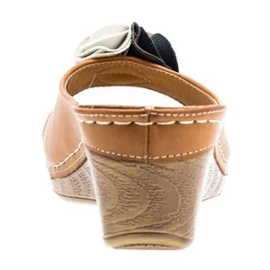 Vista posterior de sandalias con cuña marrones con flores y suela de aspecto madera