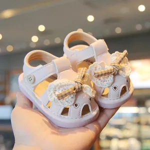 Sweet pink infant summer sandals featuring a lace bow and hollowed heart patterns.