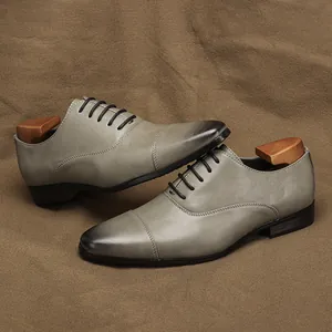 Detail view of premium grey burnished leather Oxford dress shoes with wooden shoe trees