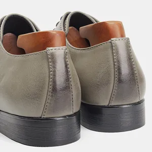 Detailed close-up showing the heel texture and stitching of grey leather dress shoes