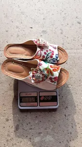 Detailansicht floraler Keilsandaletten auf einer Waage mit einem Gewicht von 172 g.