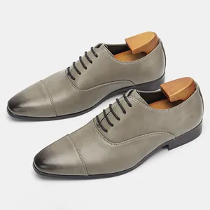 Detail view of classic grey men's Oxford dress shoes with burnished toe and matte finish