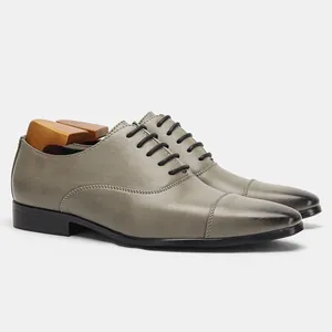 Detailed side view of premium grey leather Oxford dress shoes with a vintage burnished toe finish
