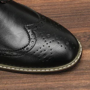Gros plan de chaussures brogues en cuir noir pour hommes avec perforations classiques