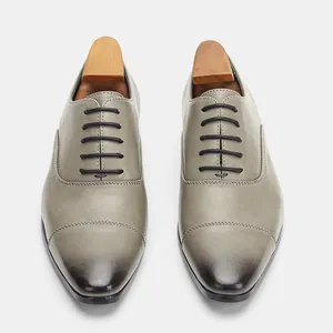 Top-down view of men's classic grey leather Oxford shoes with gradient toe detail