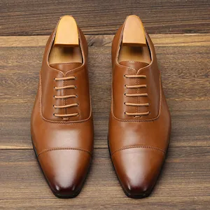 Detailed top view of classic brown leather cap-toe Oxford shoes with shoe trees
