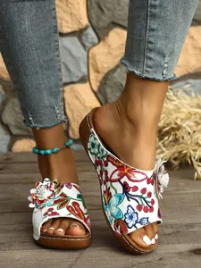 Detailansicht der Vintage-Keilsandalen mit Blumenmuster, Plateau und 3D-Blumenakzent.