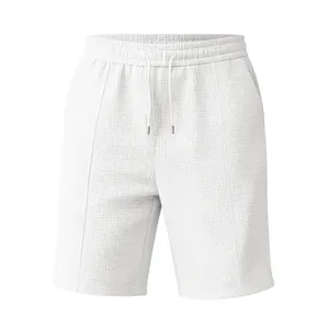 Détail du short de sport blanc gaufré pour homme montrant la texture du tissu et le cordon.