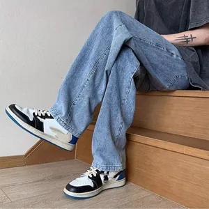 Close-up of men's loose straight-leg blue denim jeans in a high street style